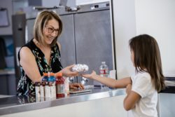 photo, parent serving lunch to a scholar